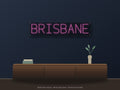 Brisbane City Name Neon Sign shown above a walnut console in a styled room mockup
