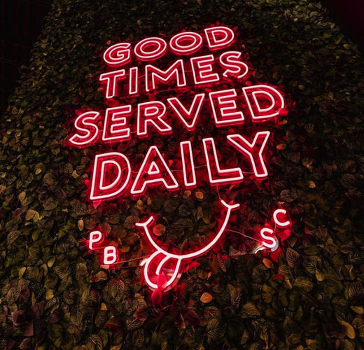 Custom neon sign spelling Good Times Served Daily in red LED letters