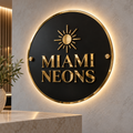 Illustrative mockup of a black round acrylic Miami Neons business sign with raised gold lettering and warm-white LED backlighting