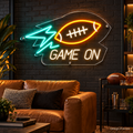 Design Preview: Kickoff Bolt Neon Sign in a modern sports lounge with charcoal brick, a caramel leather sofa, a black steel drinks cart and an unbranded football; energetic but refined. Generated room visualization, predefined colors shown.
